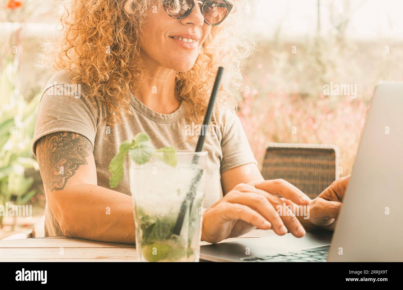 Portrait de femme de technologie travailleur utilisant l'ordinateur portable au bar de café avec mojito cocktail et sourire. Les petits entrepreneurs nomades numériques avec ordinateur et connexion Internet en itinérance. Travail en dehors du bureau Banque D'Images