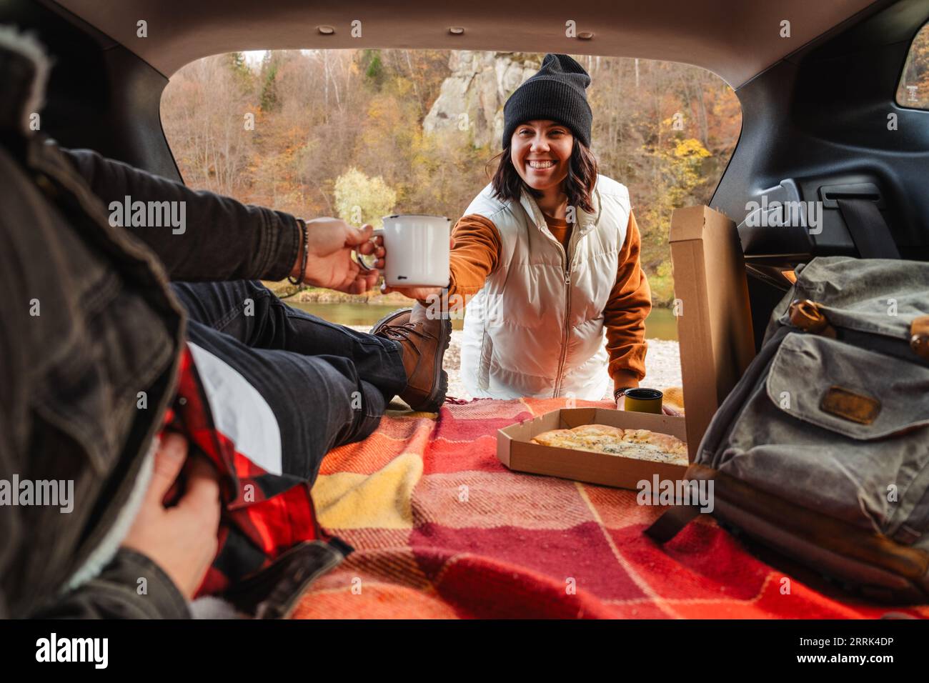 couple assis dans le coffre de voiture ayant pique-nique reposant à la nature Banque D'Images