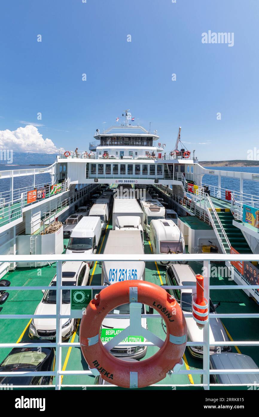 Croatie, baie de Kvarner, côte Adriatique, ferry de Lopar (île de Rab) à Valbiska (île de Krk), vue depuis le ferry avec les voitures garées et les passagers sur le pont Banque D'Images