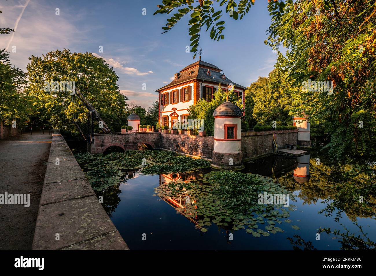 Château d'eau / Château à douves Seligenstadt dans un beau parc avec lac et reflet dans l'eau dans la soirée au coucher du soleil, Hesse, Allemagne Banque D'Images