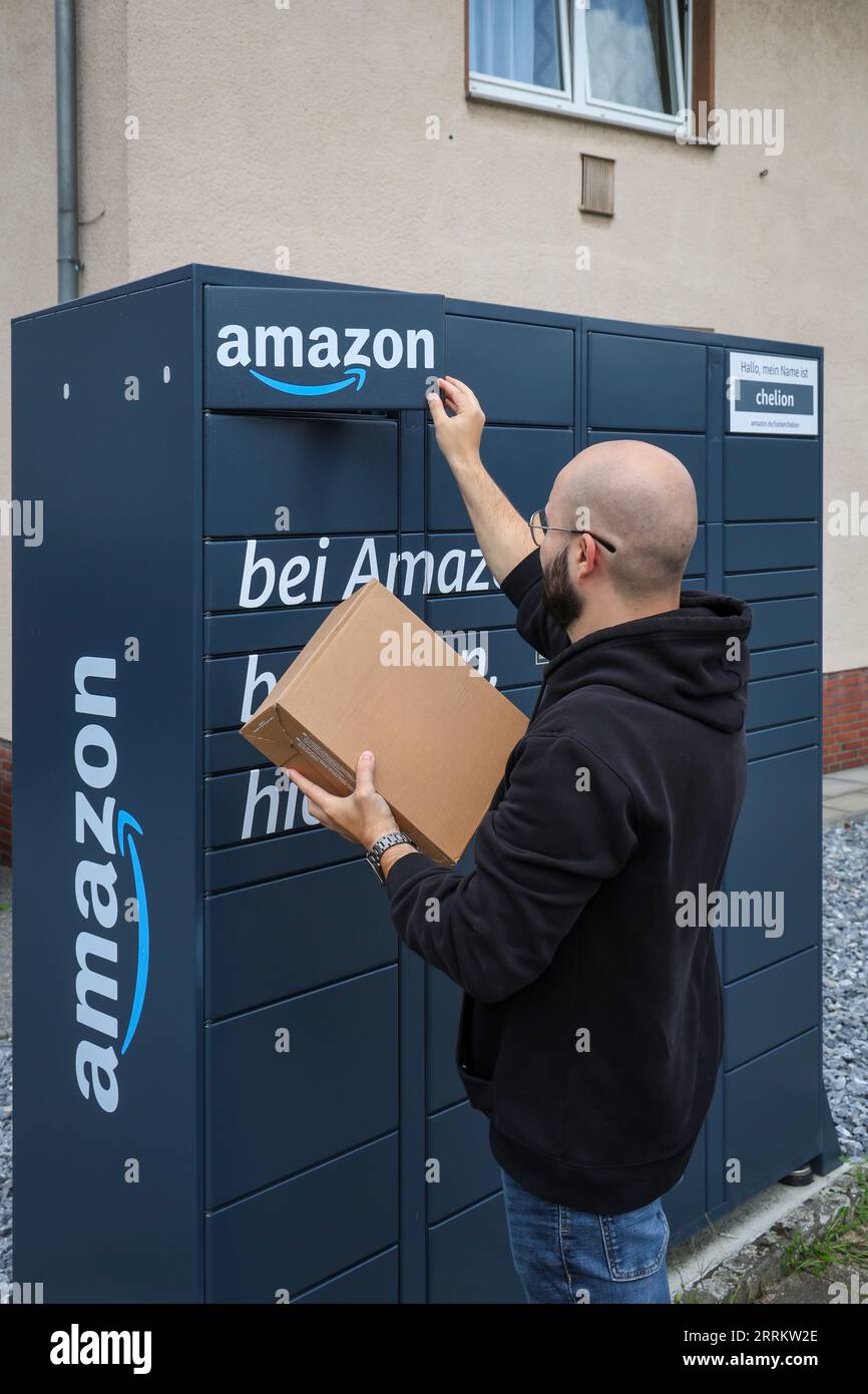 Bottrop, Rhénanie du Nord-Westphalie, Allemagne - Amazon, Amazon Locker, Amazon Hub, Packstation, station de colis, station de ramassage, le client ramasse le colis, un client ouvre un rabat avec une application sur son téléphone portable et sort son colis. Banque D'Images Bottrop, Rhénanie du Nord-Westphalie, Allemagne - Amazon, Amazon Locker, Amazon Hub, Packstation, station de colis, station de ramassage, le client ramasse le colis, un client ouvre un rabat avec une application sur son téléphone portable et sort son colis. Banque D'Images
