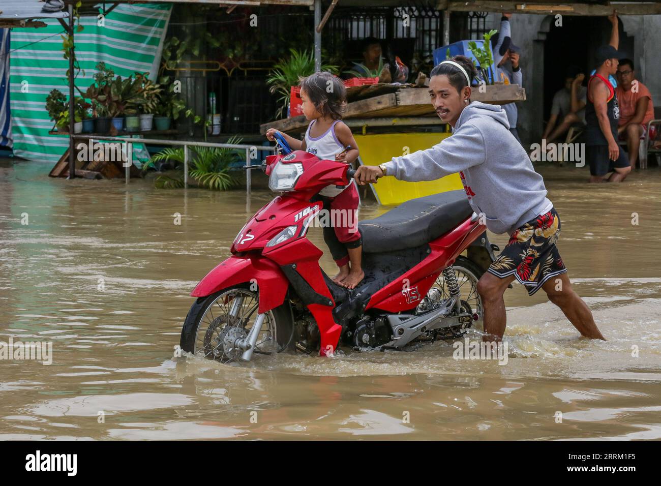 220926 -- BULACAN, le 26 septembre 2022 -- Un homme pousse sa moto avec un enfant à bord sur une route inondée dans la province de Bulacan, aux Philippines, le 26 septembre 2022. Le super typhon Noru a frappé l'île de Luzon aux Philippines avec de fortes pluies et des vents depuis dimanche après-midi, faisant cinq morts, alors qu'il a soufflé du pays d'Asie du Sud-est lundi. PHILIPPINES-PROVINCE DE BULACAN-SUPER TYPHON NORU ROUELLEXUMALI PUBLICATIONXNOTXINXCHN Banque D'Images