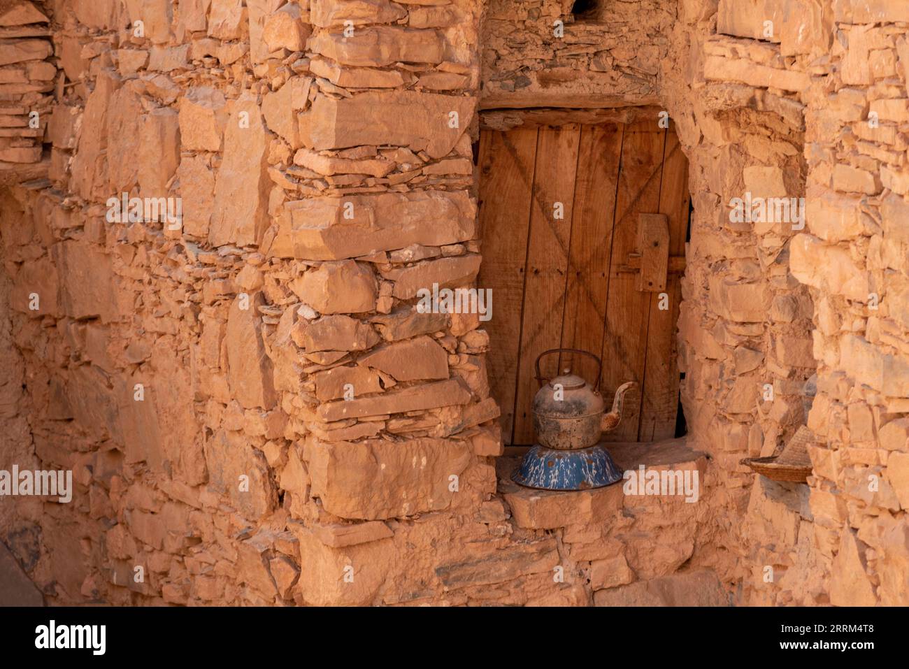 Une vieille boîte de thé devant une ancienne fenêtre d'une maison berbère au Maroc Banque D'Images