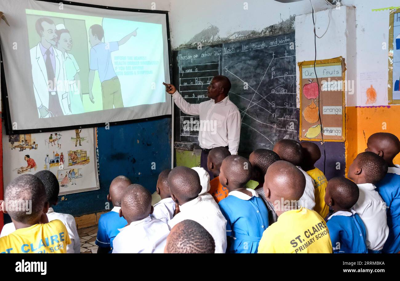 221015 -- WAKISO, 15 octobre 2022 -- des élèves assistent à un cours sur Ebola à l'aide d'un projecteur StarTimes à St. École primaire Claire à Kampala, Ouganda, 13 octobre 2022. Le projet d'accès à la télévision par satellite pour 10 000 villages africains en Ouganda est mis en œuvre par la télévision par satellite chinoise StarTimes. Ce projet est l ' un des fruits des résolutions du Forum sur la coopération sino-africaine de Johannesburg, qui s ' est tenu en 2015 en Afrique du Sud. POUR ALLER AVEC la caractéristique : la télévision par satellite aidée par la Chine relie des villages ougandais éloignés au monde extérieur photo de Hajarah Nalwadda/Xinhua UGANDA-SATELLITE TV-STARTIMES JixLi P. Banque D'Images