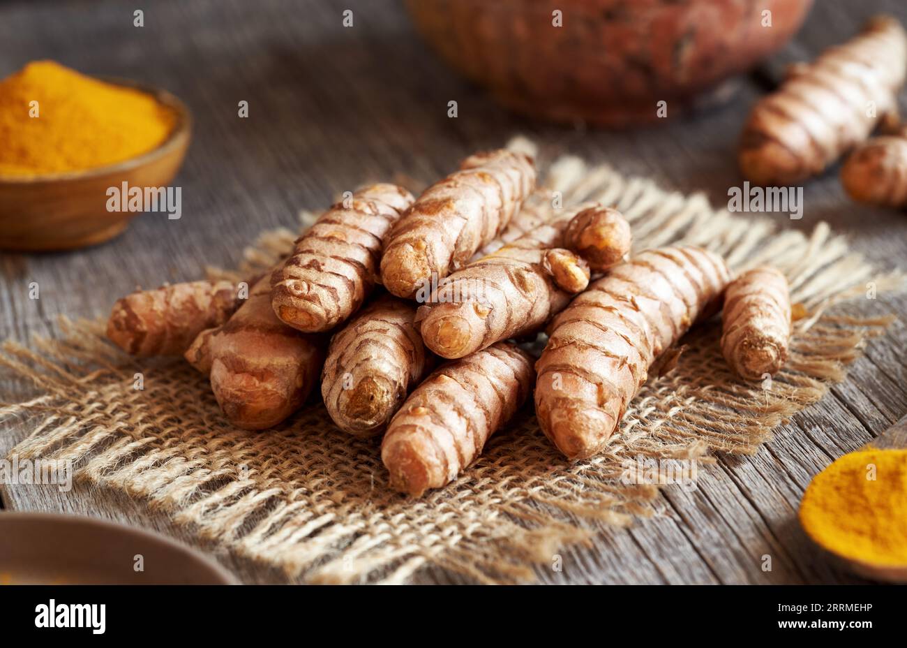 Racine de curcuma fraîche et poudre de curcuma broyée sur une table Banque D'Images