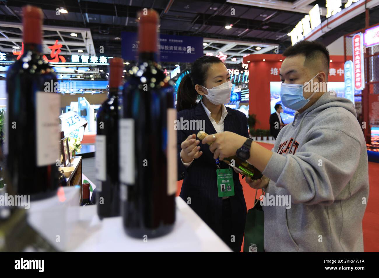 221118 -- SHENYANG, le 18 novembre 2022 -- Un visiteur regarde une bouteille de vin pendant qu'un exposant élabore lors d'une exposition lors de la Foire internationale de l'investissement et du commerce du Liaoning 2022 à Shenyang, dans la province du Liaoning du nord-est de la Chine, le 18 novembre 2022. La Foire internationale de l'investissement et du commerce Liaoning 2022 a débuté vendredi. Thématique Extend Opening-up Channel, Share Green Development, la foire vise à promouvoir les réalisations de revitalisation et de développement du Liaoning, et à stimuler la coopération économique et commerciale entre la province et les autres parties. CHINE-LIAONING-SHENYANG-INVE Banque D'Images