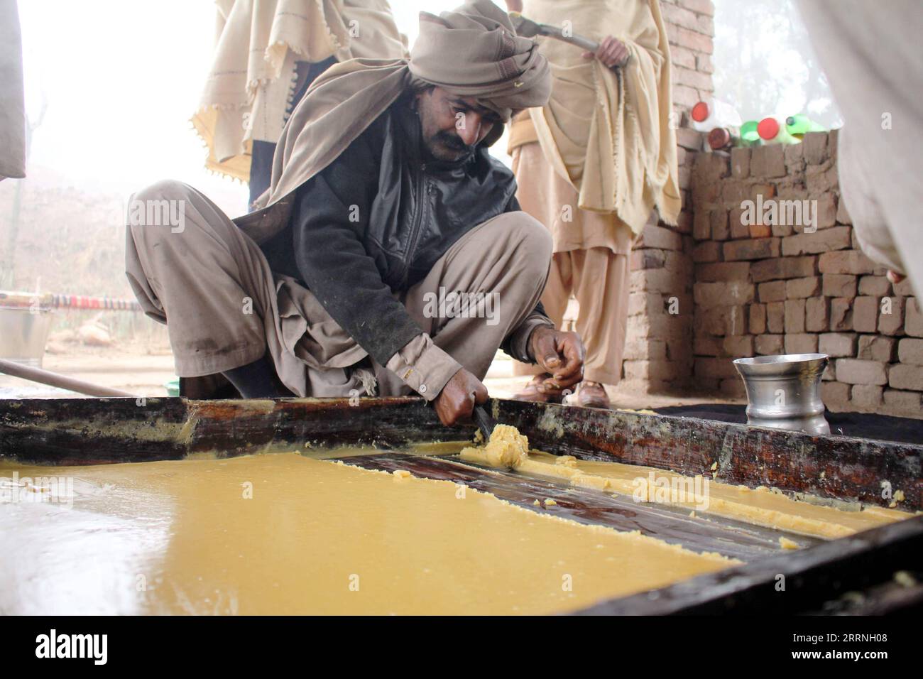 230112 -- MULTAN, le 12 janvier 2023 -- Un homme fabrique du jaggery, une sorte de bonbon traditionnel populaire parmi la population locale, à Multan, Pakistan, le 12 janvier 2023. Photo de /Xinhua PAKISTAN-MULTAN-JAGGERY MAKING Mansoor PUBLICATIONxNOTxINxCHN Banque D'Images