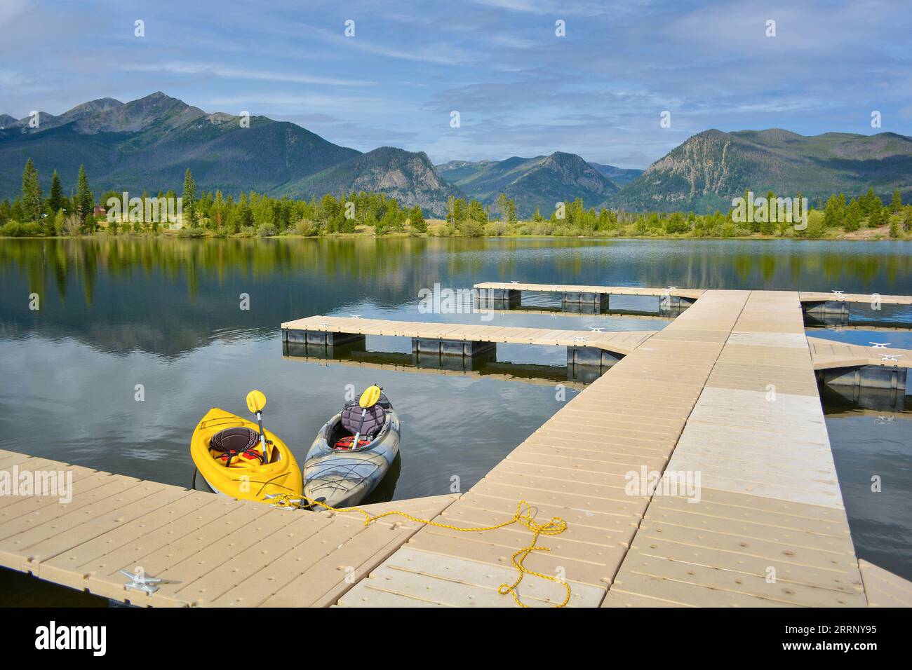 Kayaks flottant sur un lac de montagne à un quai pendant la journée Banque D'Images