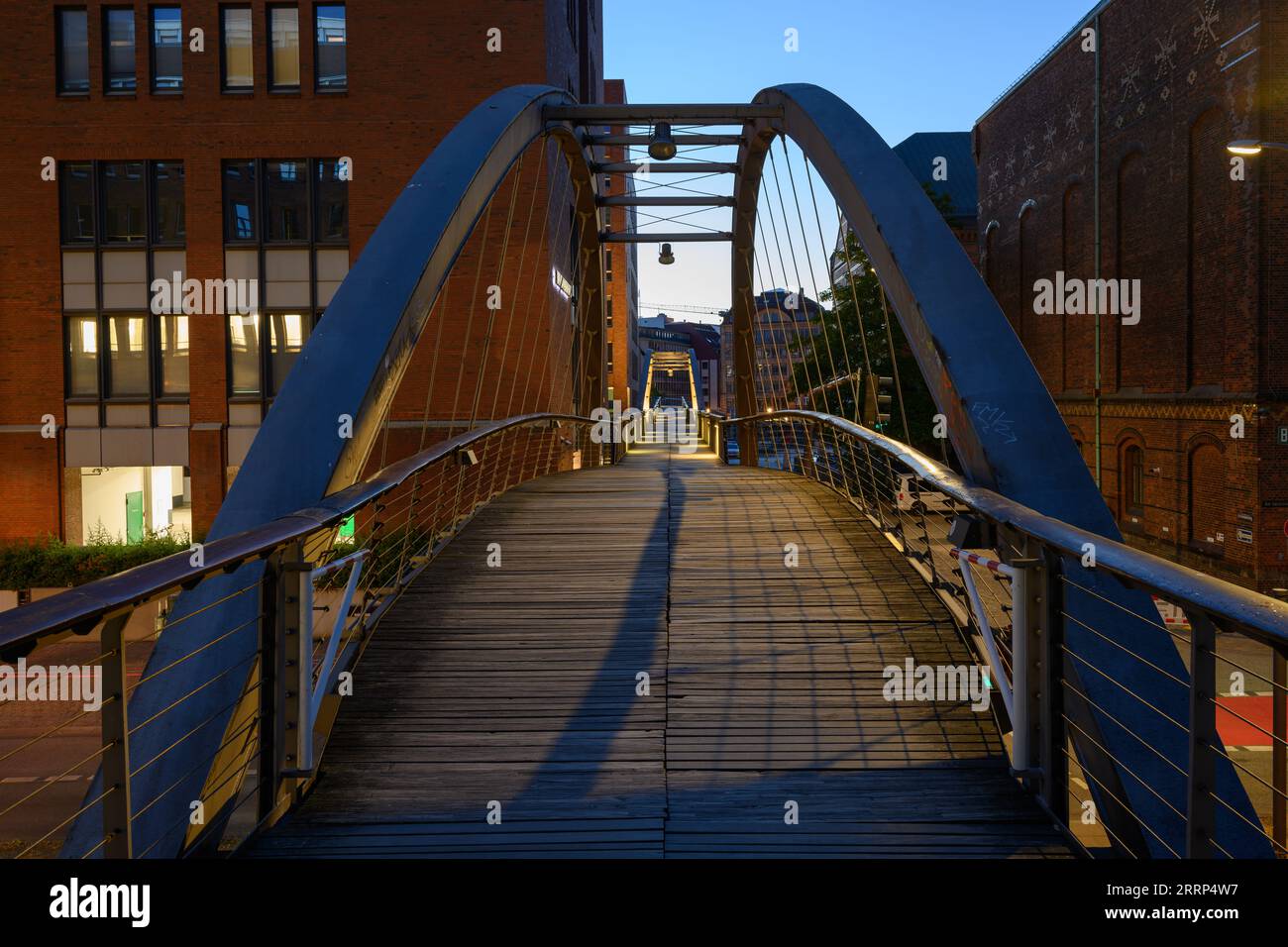 Hambourg, Allemagne - juillet 13 2023 : passerelle Kehrwiedersteg ou pont Kehrwieder dans l'heure bleue au crépuscule illuminé. Banque D'Images