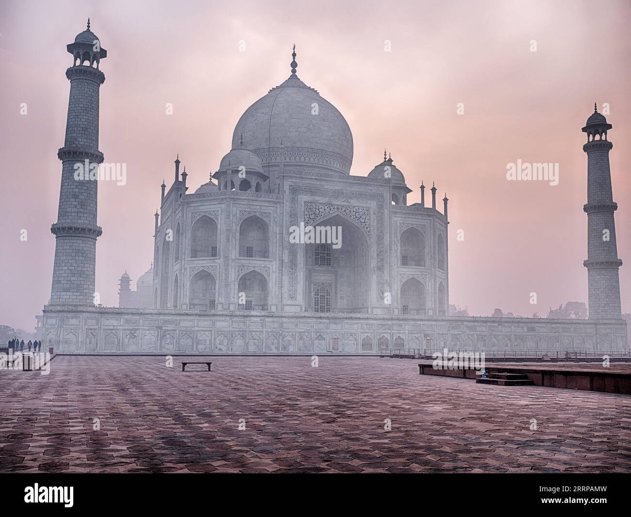 Au lever du soleil, une place vide mène au dôme du Taj Mahal à Agra est enveloppé de smog et de brume matinale un jour de décembre 2022. Banque D'Images