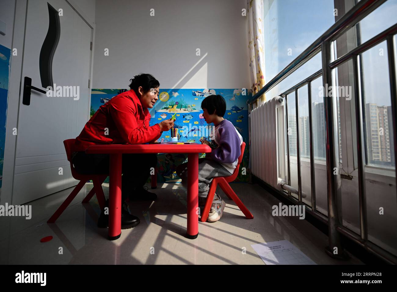 230402 -- XINING, le 2 avril 2023 -- Chen Zhifang L présente une formation de réadaptation pour un enfant autiste au centre de services spéciaux pour enfants Starlight à Xining, dans la province du Qinghai, dans le nord-ouest de la Chine, le 30 mars 2023. Chen Zhifang est le fondateur du Starlight Special Children Service Center à Xining. Fondé en 2015, le centre de services est un organisme de bien-être public à but non lucratif qui offre une formation et une intervention en réadaptation précoce aux enfants atteints d'autisme, de déficience intellectuelle et de troubles du langage. Actuellement, 132 enfants autistes reçoivent diverses formations de réadaptation HE Banque D'Images