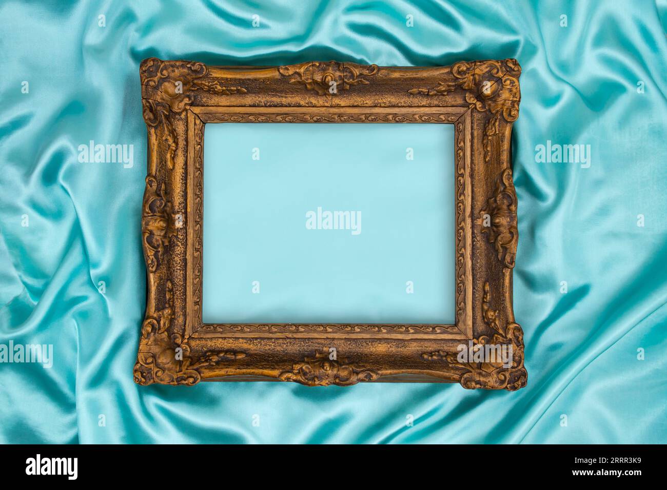 Beau cadre doré décoré classique sur bleu, satin soyeux turquoise. Fond turquoise de luxe avec espace de copie flou pour la conception. Elément Web s Banque D'Images