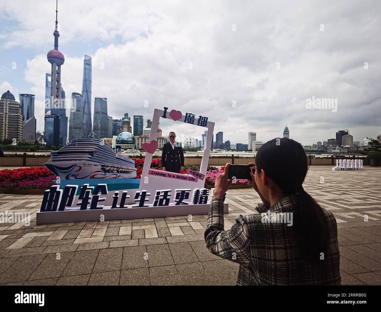 230520 -- SHANGHAI, le 20 mai 2023 -- Un homme pose pour la photo par une décoration sur le thème de la ville magique d'Adora le long de la rivière Huangpu à Shanghai, dans l'est de la Chine, le 19 mai 2023. POUR ALLER AVEC la Chine dévoile le nom du premier grand navire de croisière construit au pays CHINE-SHANGHAI-GRAND NAVIRE DE CROISIÈRE CONSTRUIT AU PAYS CN ChenxAiping PUBLICATIONxNOTxINxCHN Banque D'Images