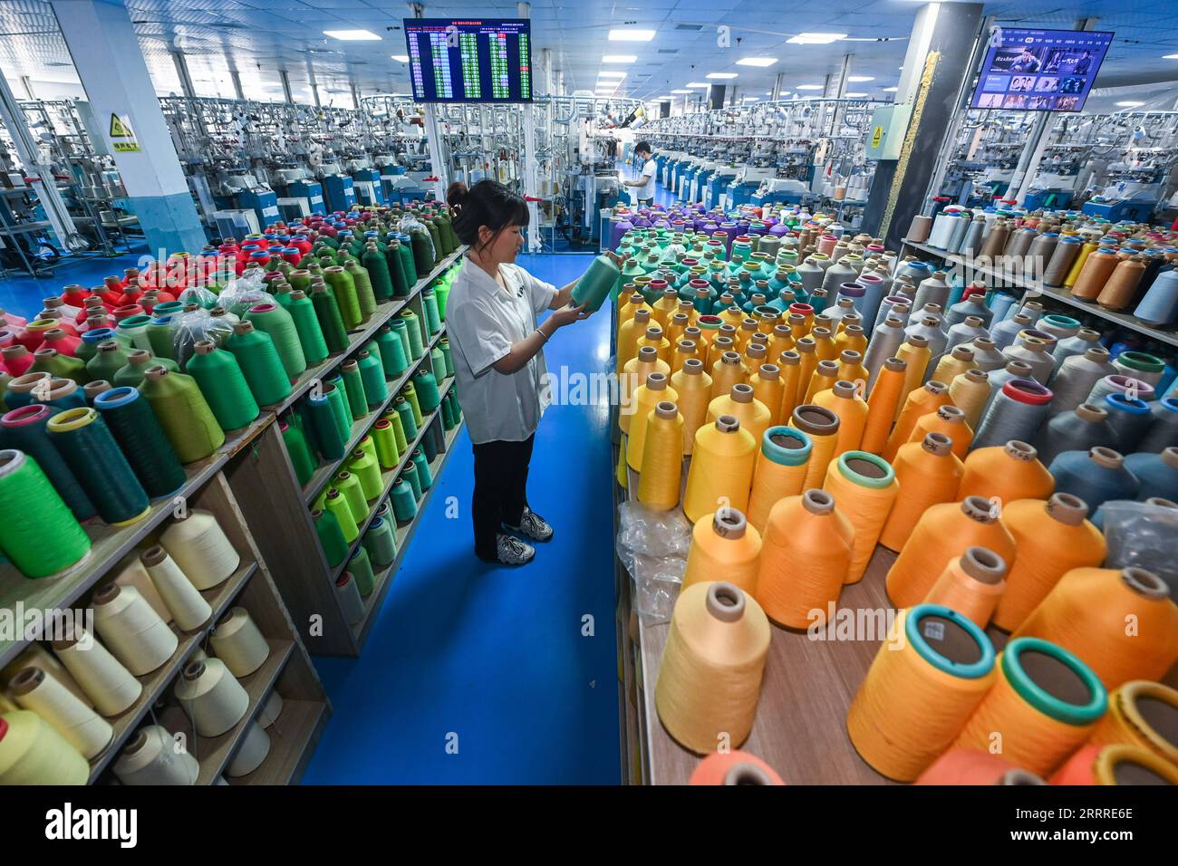 230525 -- ZHUJI, 25 mai 2023 -- Un membre du personnel choisit un rouleau de fil dans un atelier d'une entreprise de bonneterie au sous-district de Datang de la ville de Zhuji, province de Zhejiang dans l'est de la Chine, le 25 mai 2023. Le sous-district de Datang de la ville de Zhuji est la plus grande base de production de bonneterie dans le monde, qui produit 25 milliards de paires de chaussettes chaque année, représentant plus de 70% de la production de la Chine et un tiers du monde entier. Actuellement, il y a 201 entreprises industrielles au-dessus de la taille désignée dans le sous-district. La valeur totale de la production du sous-district de janvier à avril de cette année a atteint 3,54 milliards de yu Banque D'Images