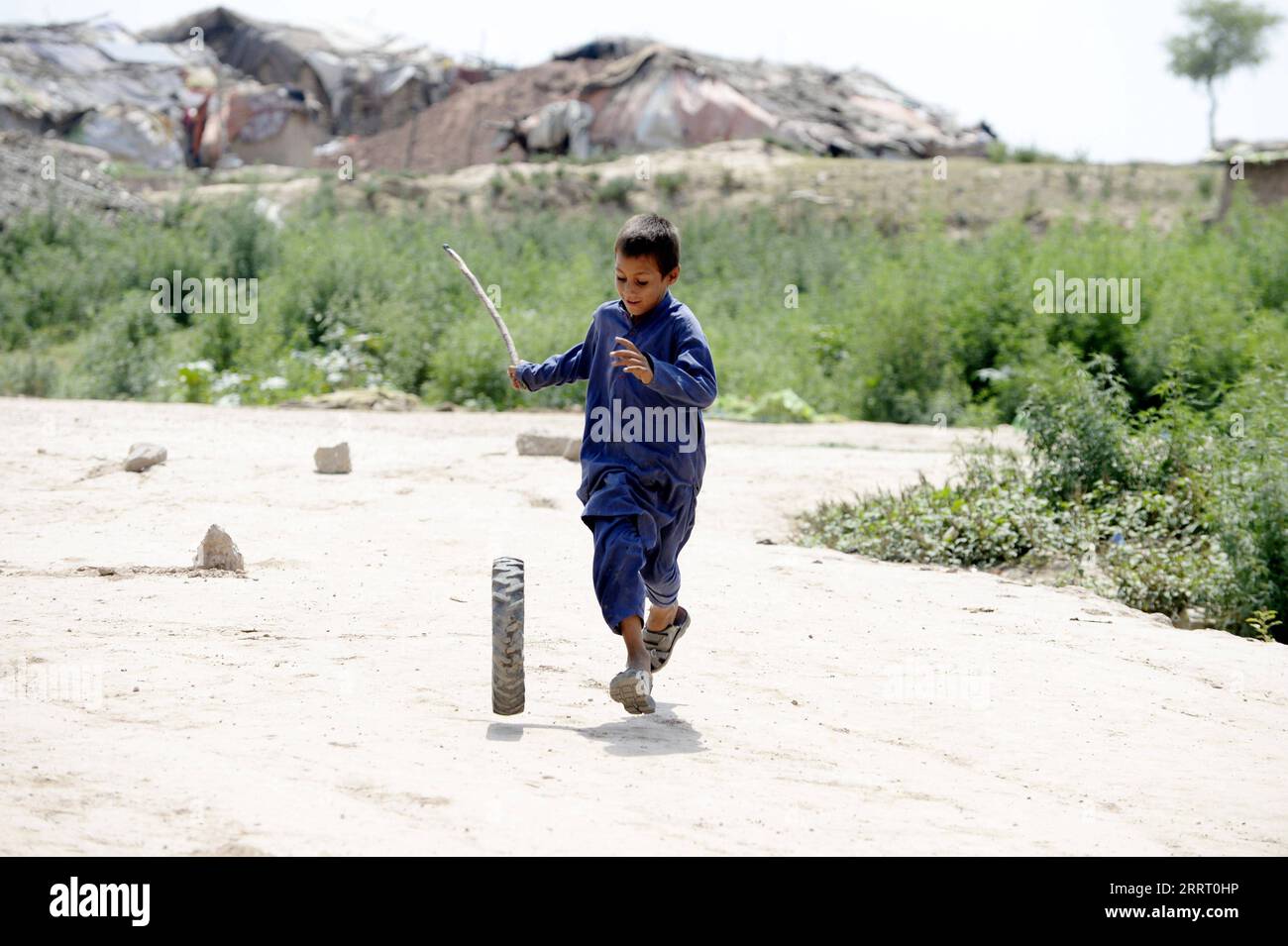 230620 -- ISLAMABAD, le 20 juin 2023 -- Un garçon joue avec un pneu dans un camp de réfugiés lors de la Journée mondiale des réfugiés à Islamabad, au Pakistan, le 20 juin 2023. Le Président pakistanais Arif Alvi a déclaré que son pays continuait d accueillir l une des plus importantes populations de réfugiés au monde, témoignant de la détermination et de l engagement indéfectibles du Pakistan en faveur du bien-être et du rapatriement librement consenti des réfugiés. Dans son message à l'occasion de la Journée mondiale des réfugiés, qui a été célébrée mardi, Alvi a déclaré que, ce jour-là, nous nous souvenons des immenses contributions du gouvernement et du peuple pakistanais pour accueillir des millions de réfugiés afghans Banque D'Images