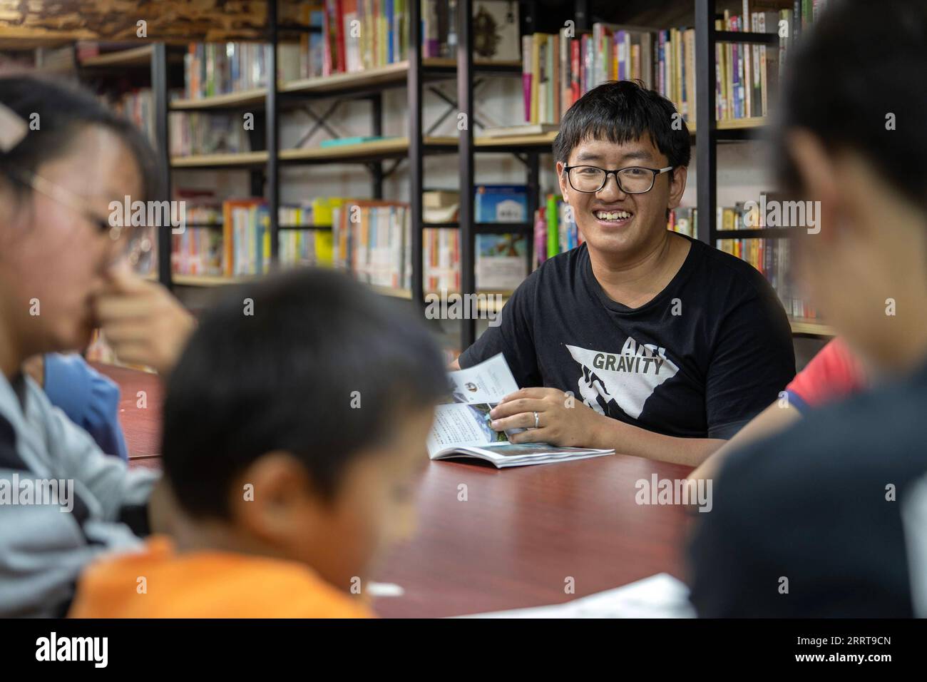 230707 -- GONGSHAN, le 7 juillet 2023 -- Gan Wenyong participe à une activité de lecture avec des enfants à la bibliothèque de Banshan Huayu dans le village de Qiunatong dans le canton de Bingzhongluo dans le comté autonome de Gongshan Dulong et nu, préfecture autonome de Lisu de Nujiang, province du Yunnan au sud-ouest de la Chine, le 5 juillet 2023. La rivière Nujiang, descendant des montagnes Tanggula sur le plateau Qinghai-Tibet, se fraie un chemin à travers les majestueuses montagnes du Yunnan où se forme un magnifique canyon. Niché à la pointe nord du canyon de la rivière Nujiang se trouve le village de Qiunatong, qui abrite une balance unique Banque D'Images