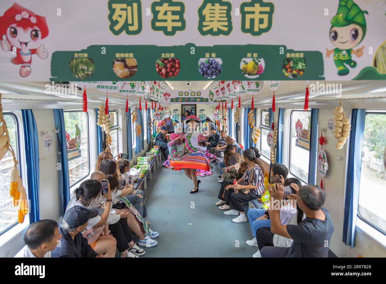 230711 -- CHONGQING, le 11 juillet 2023 -- des membres du personnel dansent à bord du train n° 5630 de Zunyi, dans la province du Guizhou du sud-ouest de la Chine, à la municipalité de Chongqing du sud-ouest de la Chine, le 11 juillet 2023. Les trains n°5630 et 5629 sont des trains lents circulant entre Zunyi de la province de Guizhou et la municipalité de Chongqing dans le sud-ouest de la Chine. Les autorités ferroviaires locales ont organisé des marchés et des spectacles à bord, qui permettent aux villageois vivant le long de la ligne de train de vendre des marchandises aux passagers et, parallèlement, offrent aux passagers une expérience de voyage spéciale. CHINE-CHONGQING-GUIZHOU-TRAIN-À BORD MARCHÉ CN HUANGXWEI Banque D'Images