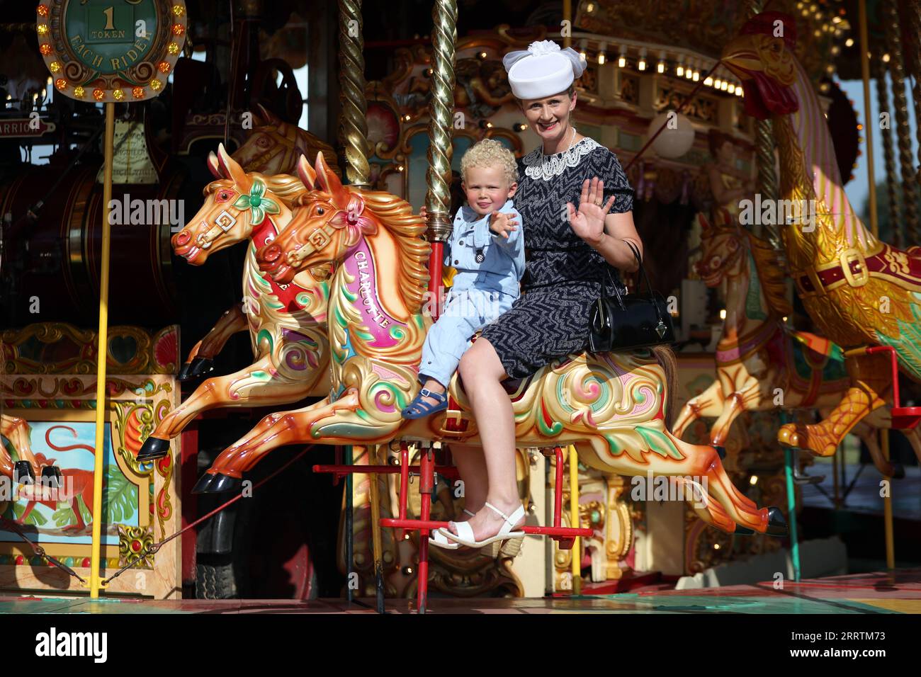 Un jeune visiteur monte sur le carrousel lors de la fête foraine vintage au Goodwood Revival au Goodwood Motor circuit dans le West Sussex. Date de la photo : Samedi 9 septembre 2023. Banque D'Images
