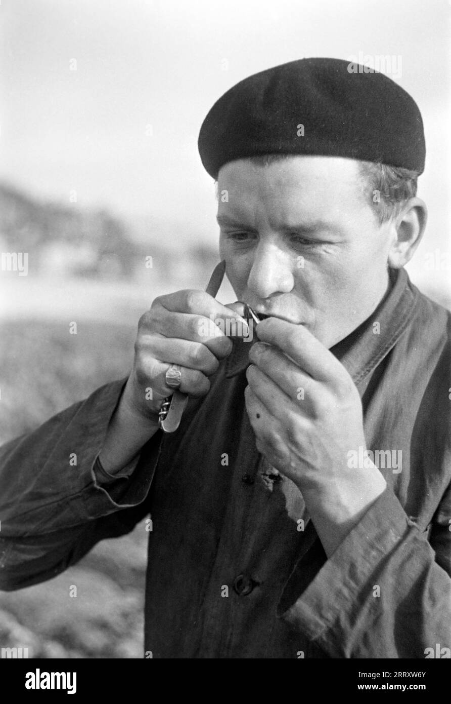 Muschelernter isst eine frische Muschel am Strand, le Havre 1940. Récolteuse de moules mangeant une moule fraîche sur la plage, le Havre 1940. Banque D'Images