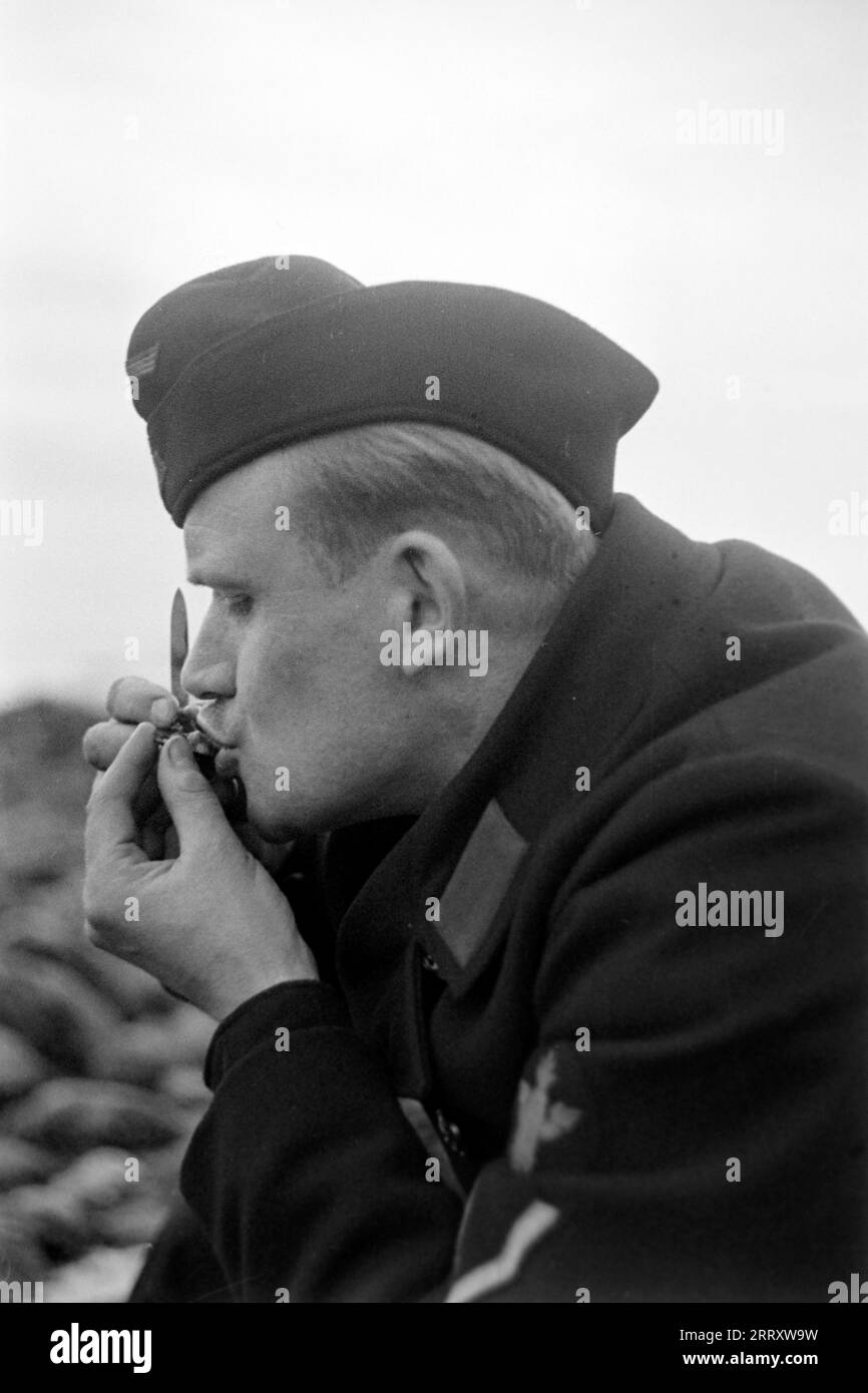 Der Fotograf Erich Andres in der Uniform der Kriegsmarine isst Muscheln am Strand von le Havre, 1940. Photographe Erich Andres dans son uniforme de Kriegsmarine mangeant des moules sur la plage du Havre, 1940. Banque D'Images