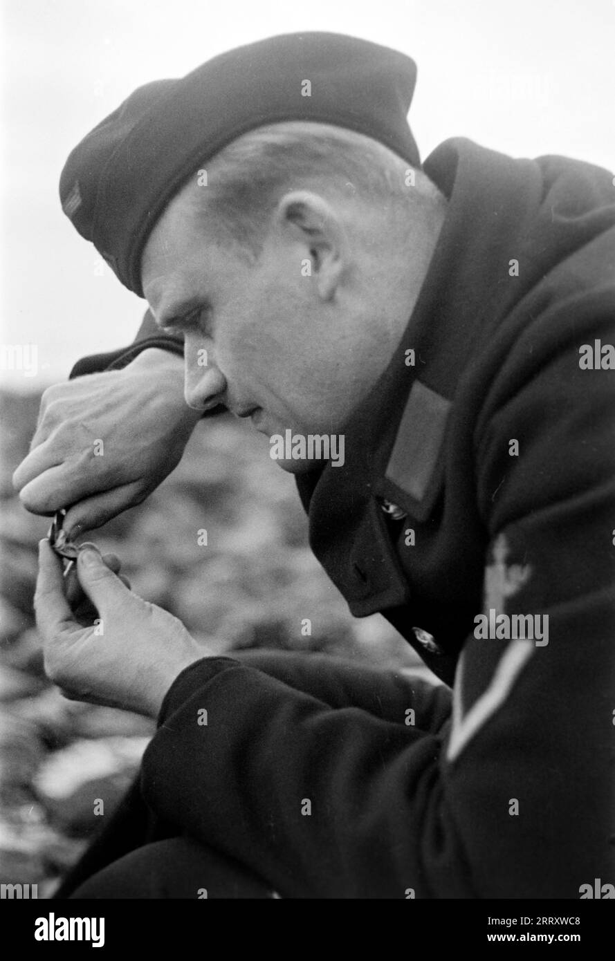 Der Fotograf Erich Andres in der Uniform der Kriegsmarine öffnet Muscheln am Strand von le Havre UM sie zu verzehren, 1940. Le photographe Erich Andres dans son uniforme de Kriegsmarine ouvre des moules sur la plage du Havre pour les manger, 1940. Banque D'Images