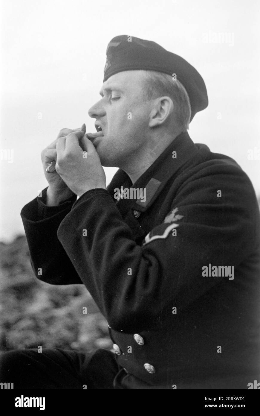 Der Fotograf Erich Andres in der Uniform der Kriegsmarine isst Muscheln am Strand von le Havre, 1940. Photographe Erich Andres dans son uniforme de Kriegsmarine mangeant des moules sur la plage du Havre, 1940. Banque D'Images