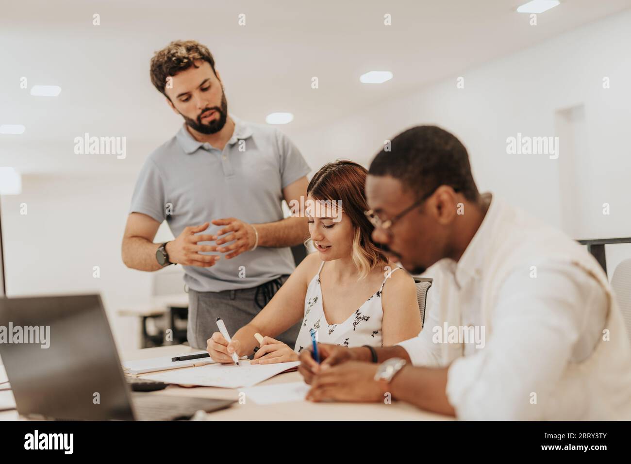 Un groupe diversifié d'employés collaborant et travaillant dans un bureau moderne. Analyser les statistiques, discuter des revenus de croissance des bénéfices et planifier le projet Banque D'Images