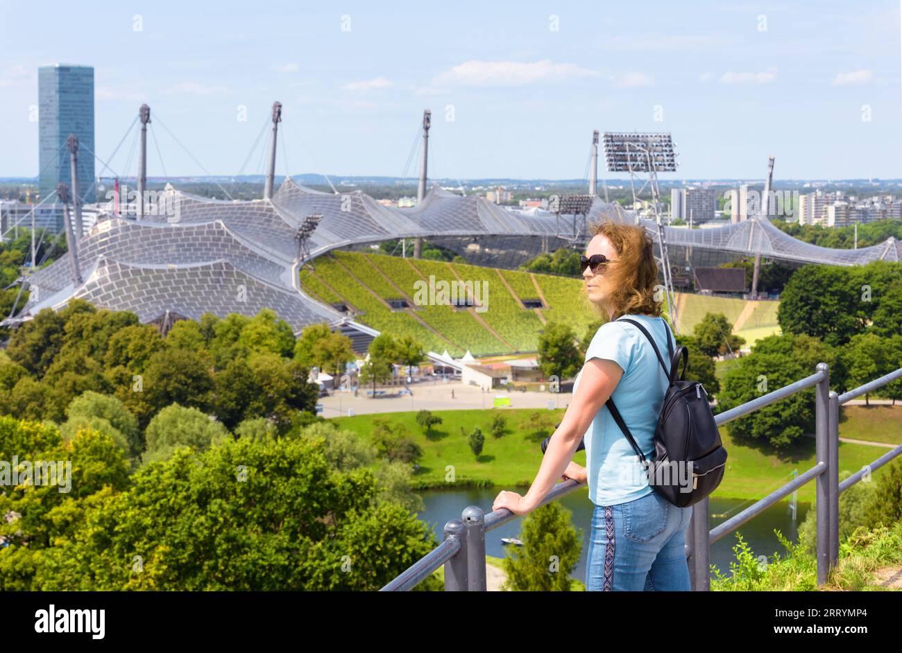 Jeune femme touristique visite le parc olympique en été, Munich, Allemagne. Cet endroit est célèbre point de repère de la ville de Munchen. Concept de voyage, de tourisme et de soupir Banque D'Images