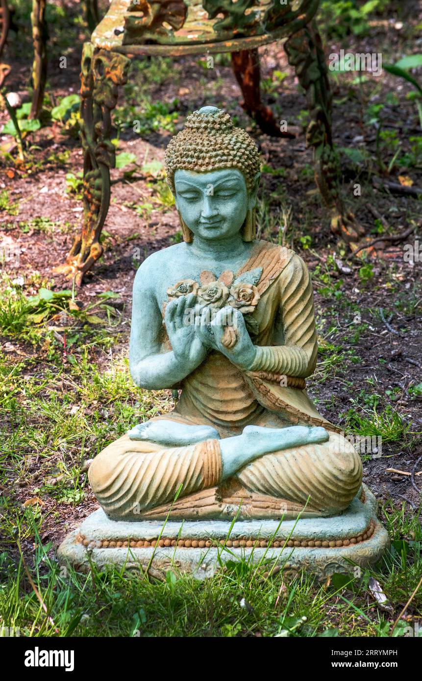 Une belle statue de Bouddha chinois repose dans le jardin extérieur, créant un espace zen pour la détente et la médiation Banque D'Images