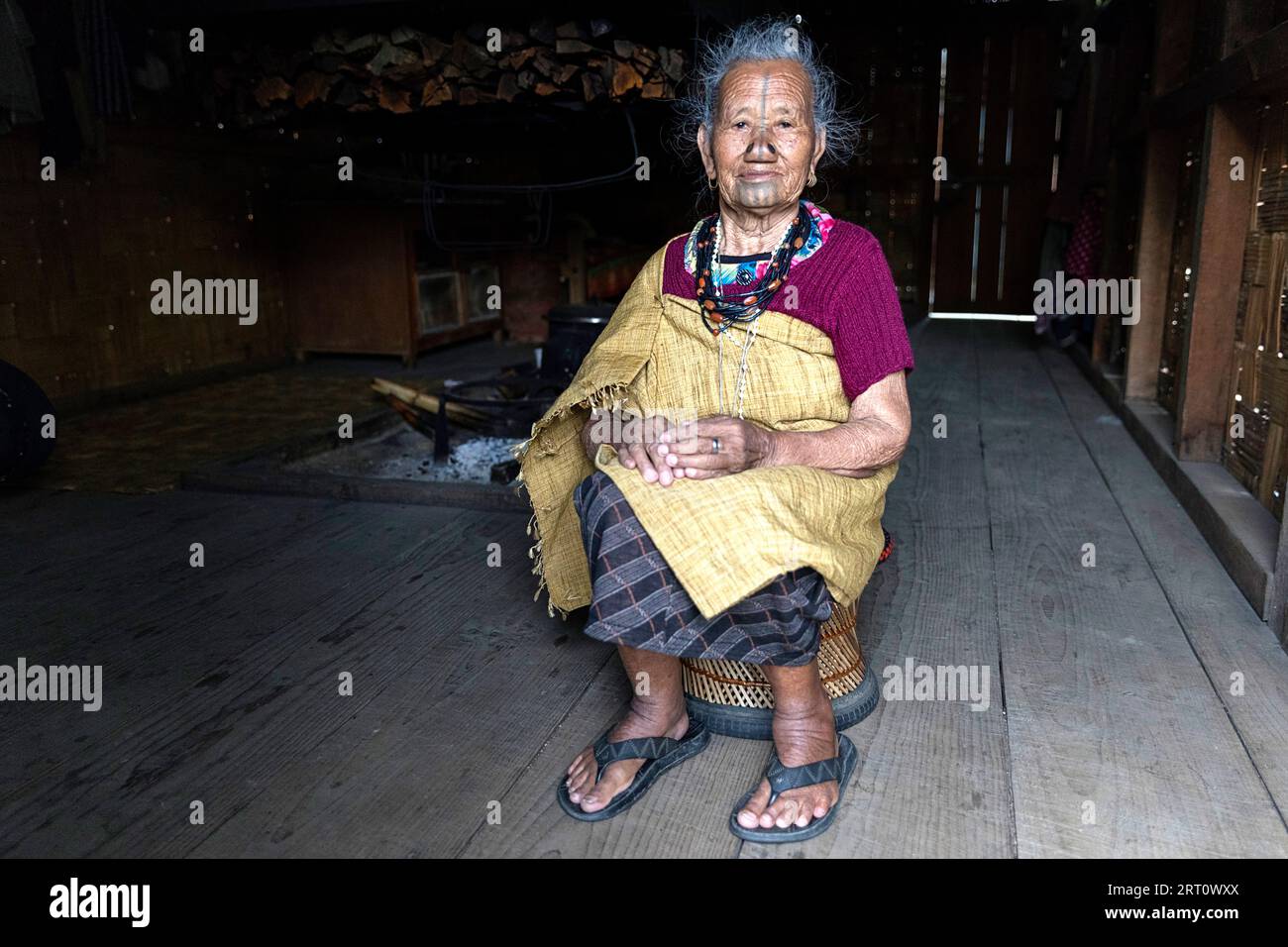 Femme de la tribu apatani dans une maison d'un petit village près de Ziro, avec des tatouages faciaux traditionnels et des bouchons de nez traditionnels, Ziro, Inde Banque D'Images