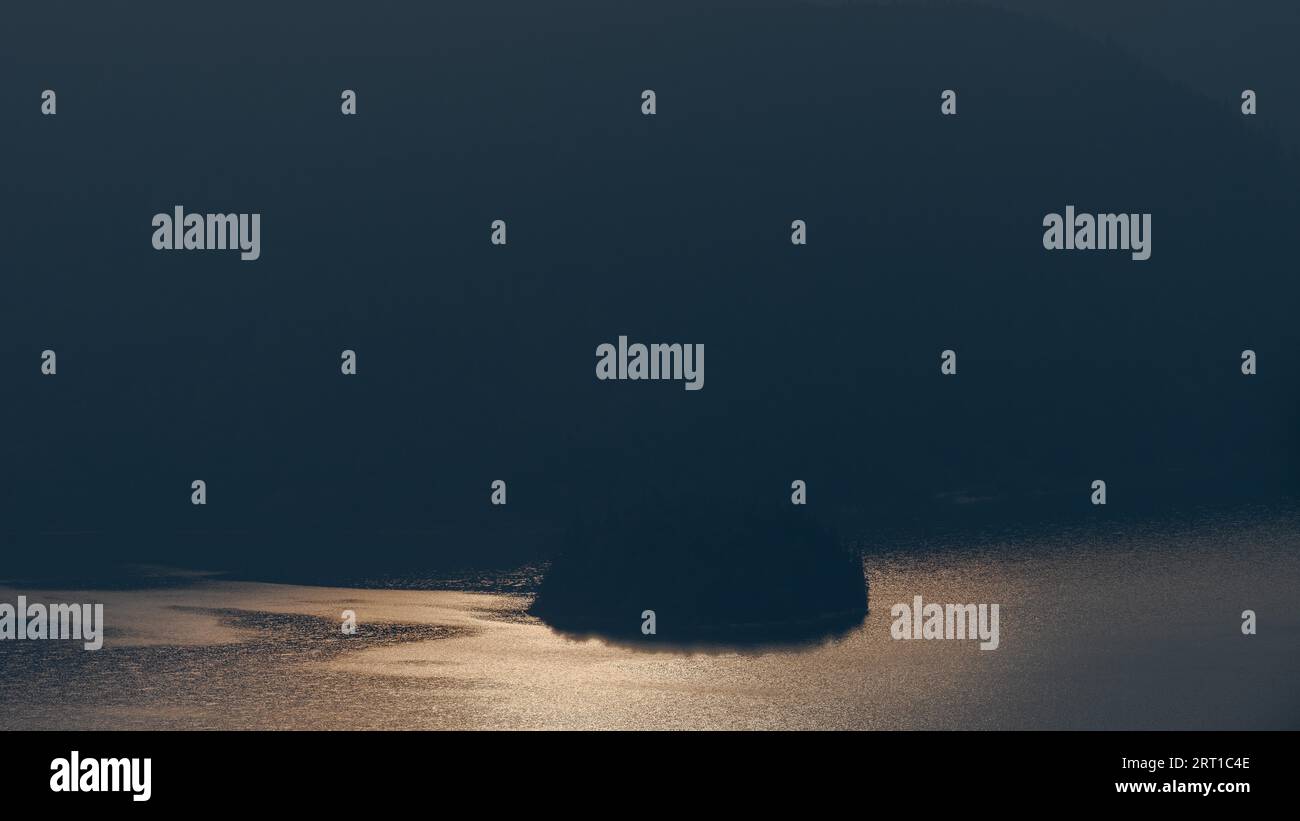 La petite île de Sassau dans le lac de montagne Walchensee en Bavière dans la lumière dorée du matin Banque D'Images La petite île de Sassau dans le lac de montagne Walchensee en Bavière dans la lumière dorée du matin Banque D'Images