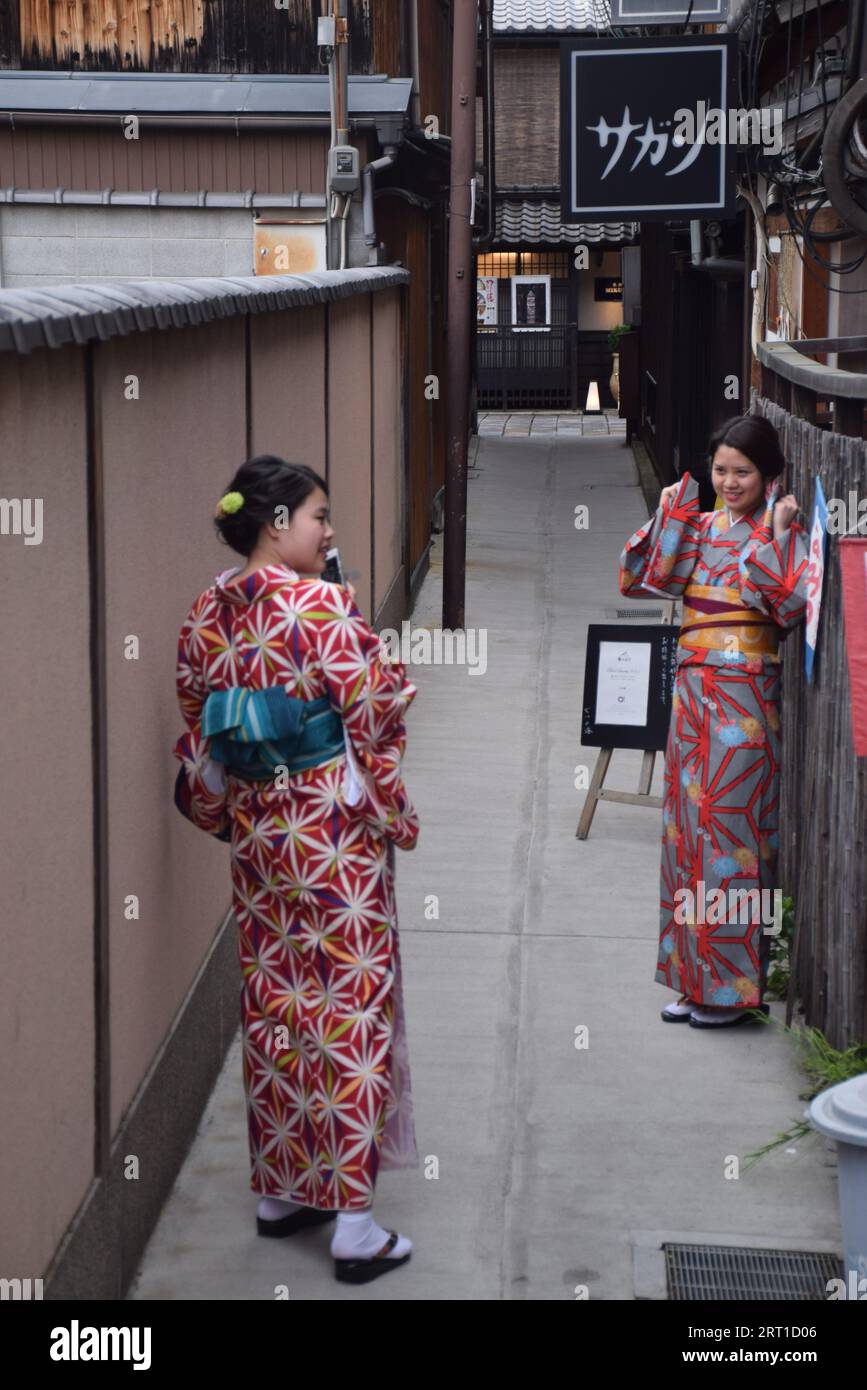 Deux jeunes filles japonaises vêtues de kimono prenant des photos dans le quartier de Gion, l'un des quartiers de geisha les plus exclusifs et les plus connus de Kyoto, au Japon Banque D'Images