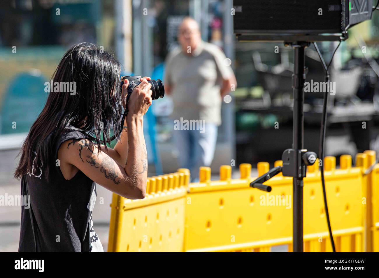 Photographe aux cheveux longs prenant une photo au Kallio Block Party 2023 à Helsinki, Finlande Banque D'Images