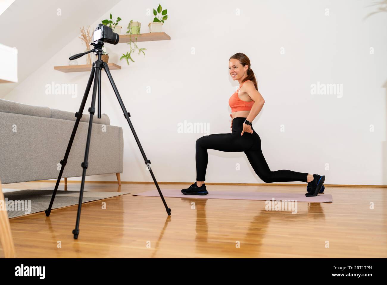 Athletic Woman entraîneur de fitness en ligne vlogger enregistrant la vidéo de l'exercice sportif pour ses médias sociaux. Banque D'Images