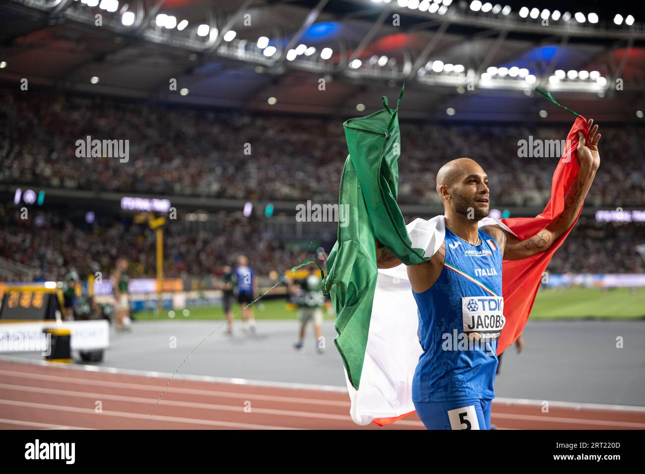 Marcell Jacobs célèbre sa médaille avec le drapeau de son pays dans le