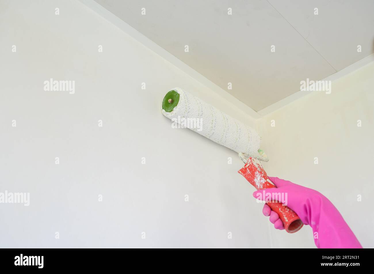 Peinture de travailleur sur le mur de surface. Peinture appartement, rénovation avec peinture de couleur blanche. Banque D'Images