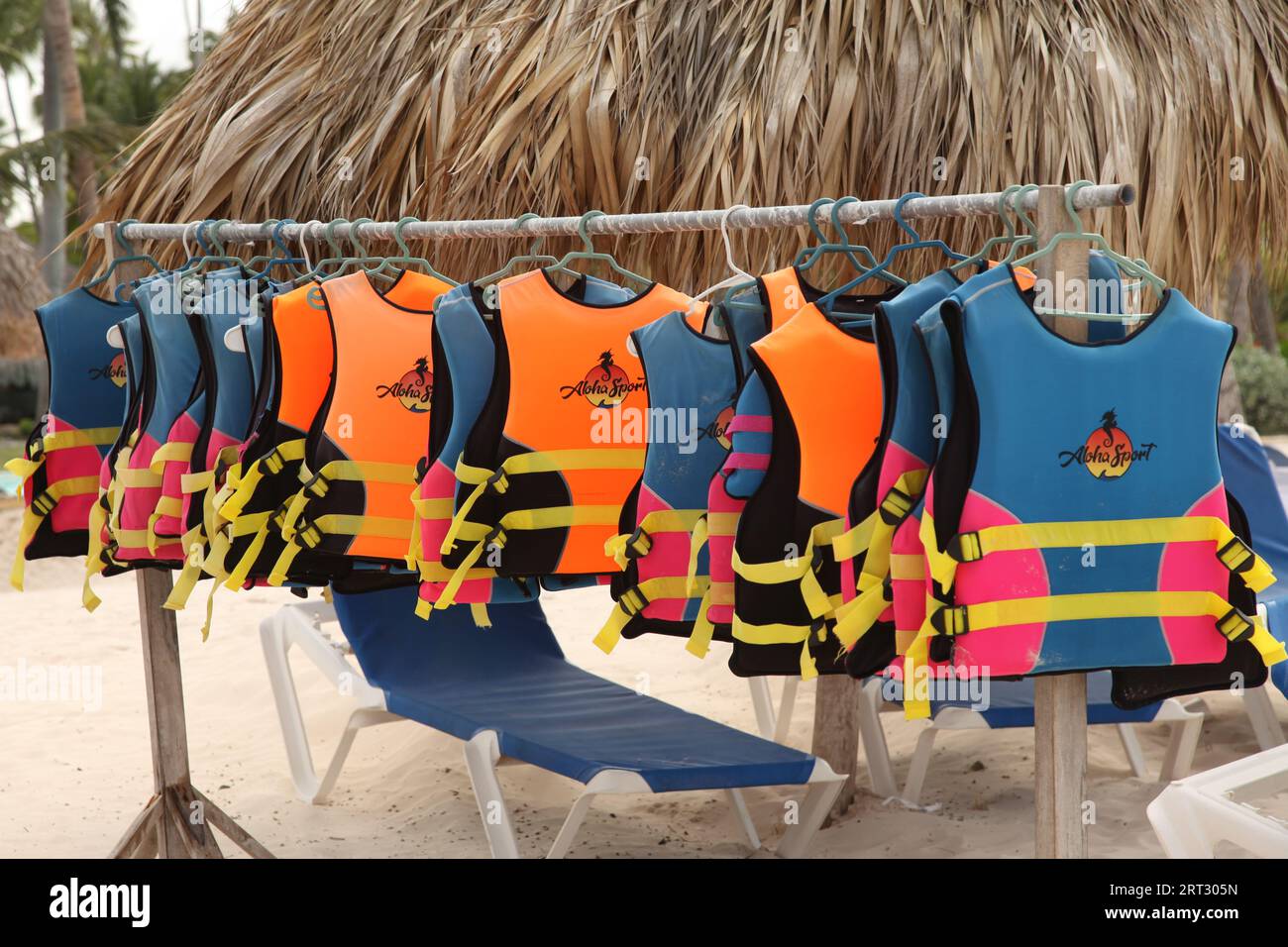 Une collection de gilets de sauvetage Aloha Sports accrochés sur un rack à une plage des Caraïbes, République Dominicaine, Punta Cana 2023 Banque D'Images