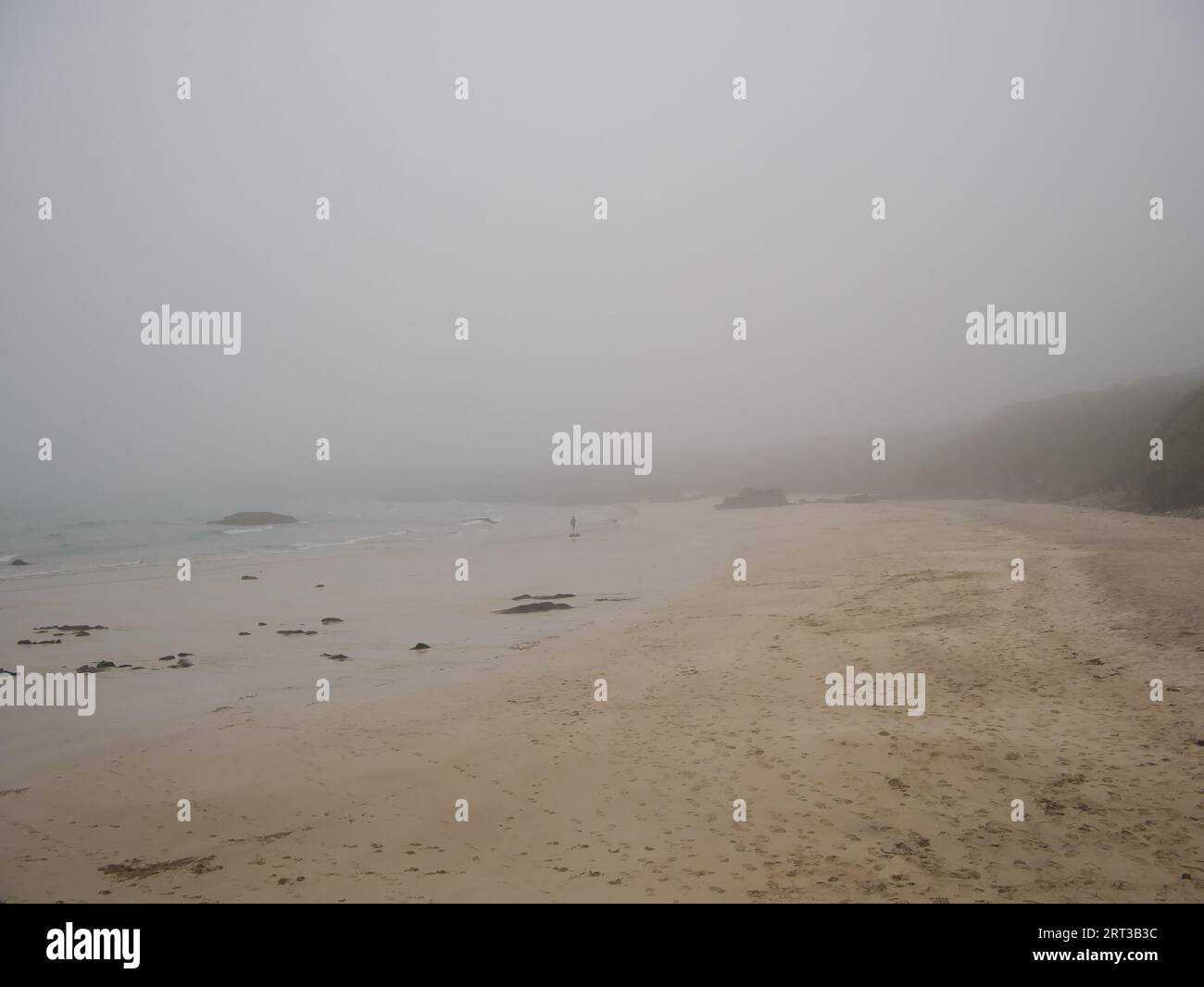 Une personne seule sur la plage du port de Ness sur l'île de Lewis, Hébrides extérieures, Écosse, Royaume-Uni. Pris un jour de dreich - humide et brumeux. Banque D'Images