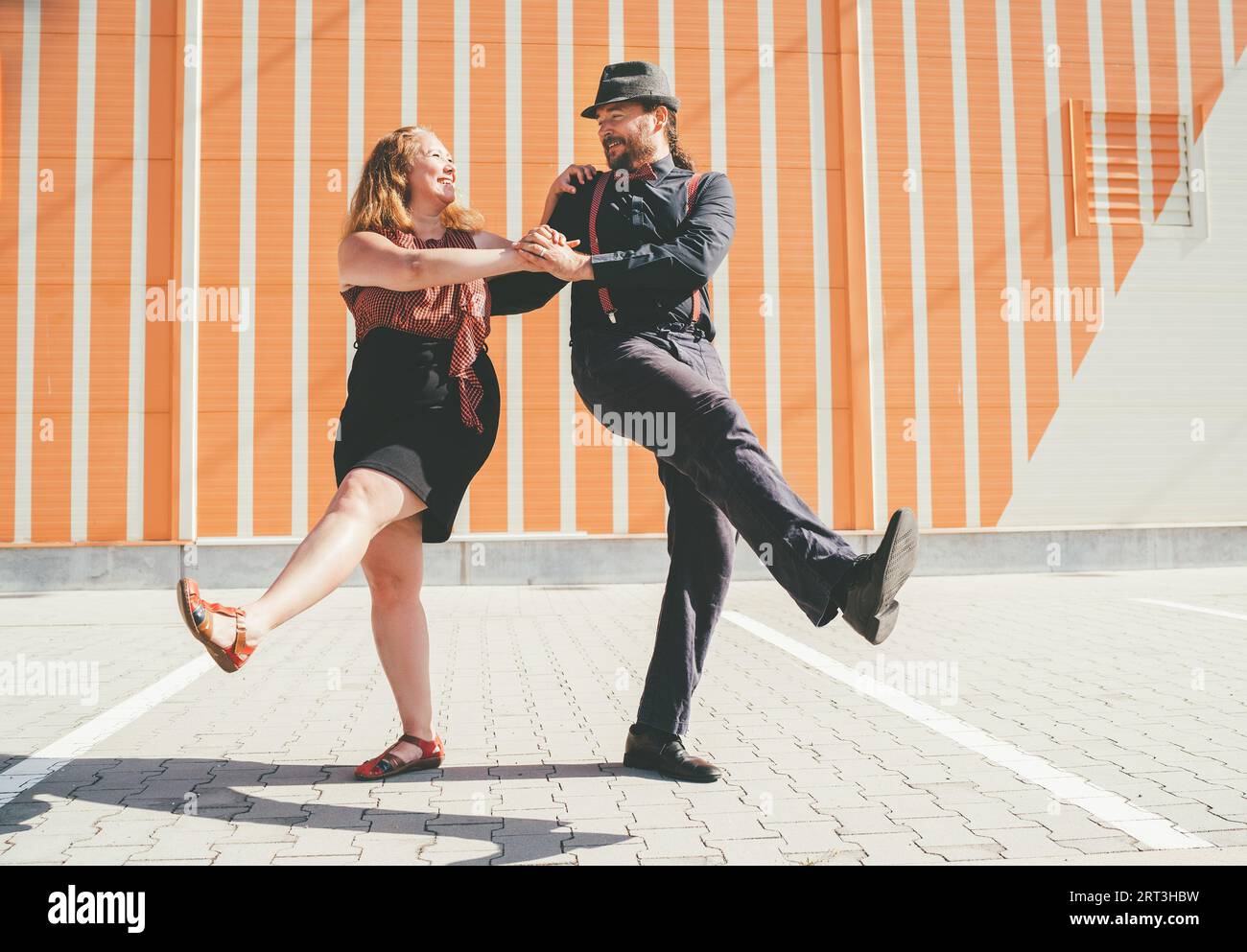 Couple joyeux dansant une danse rétro swing à la musique jazz qui était très populaire pendant l'ère West Coast Swing dans les années 1920-40 Ils sourient à chaque autre Banque D'Images