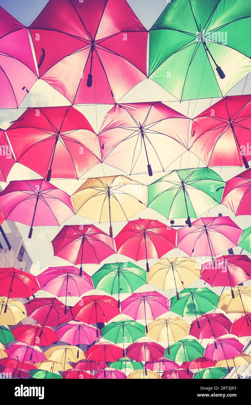 Suspendre des parapluies colorés contre le ciel, tonification de couleur appliquée. Banque D'Images