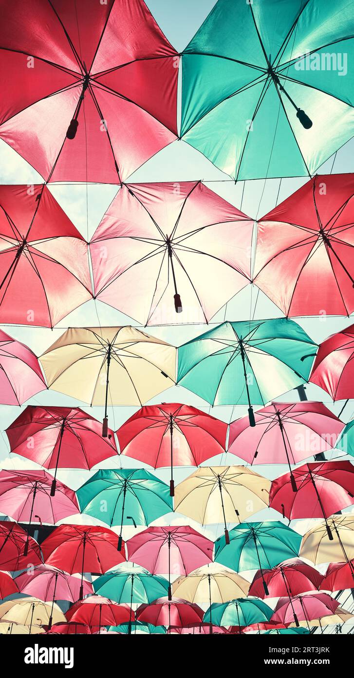 Suspendre des parapluies colorés contre le ciel, tonification de couleur appliquée. Banque D'Images