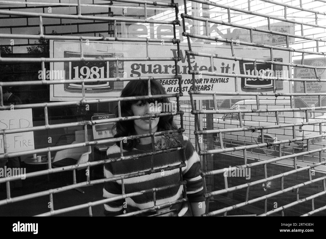 Toxteth Riot, Royaume-Uni 1981 le matin après les émeutes, un ouvrier derrière le grill métallique protégeant le magasin qui n'avait pas été pillé pendant l'émeute. Liverpool 8 Lancashire juillet 1980s HOMER SYKES Banque D'Images