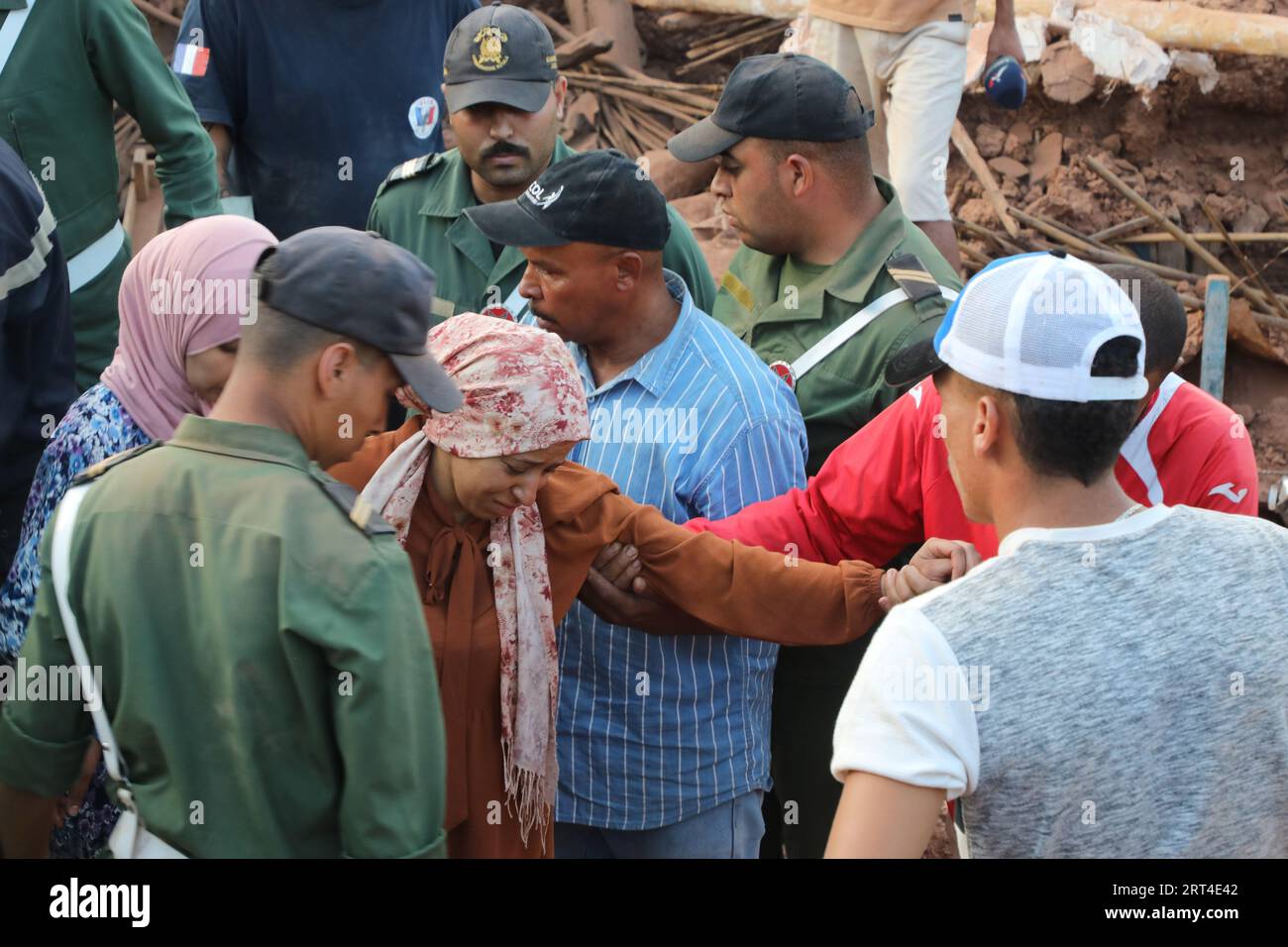 Al Haouz, Maroc. 10 septembre 2023. Des secouristes viennent en aide à une femme dans la ville de Ouirgane, au sud de Marrakech, lors d’une opération de recherche après le puissant tremblement de terre qui a frappé le Maroc vendredi dernier. Le nombre de morts dans le puissant tremblement de terre qui a frappé le Maroc vendredi dernier est passé à 2 122 personnes alors que les sauveteurs dans le pays ont couru contre la montre à la recherche de survivants potentiels dans une mission difficile dans des zones montagneuses reculées. Crédit : Khaled Nasraoui/dpa/Alamy Live News Banque D'Images