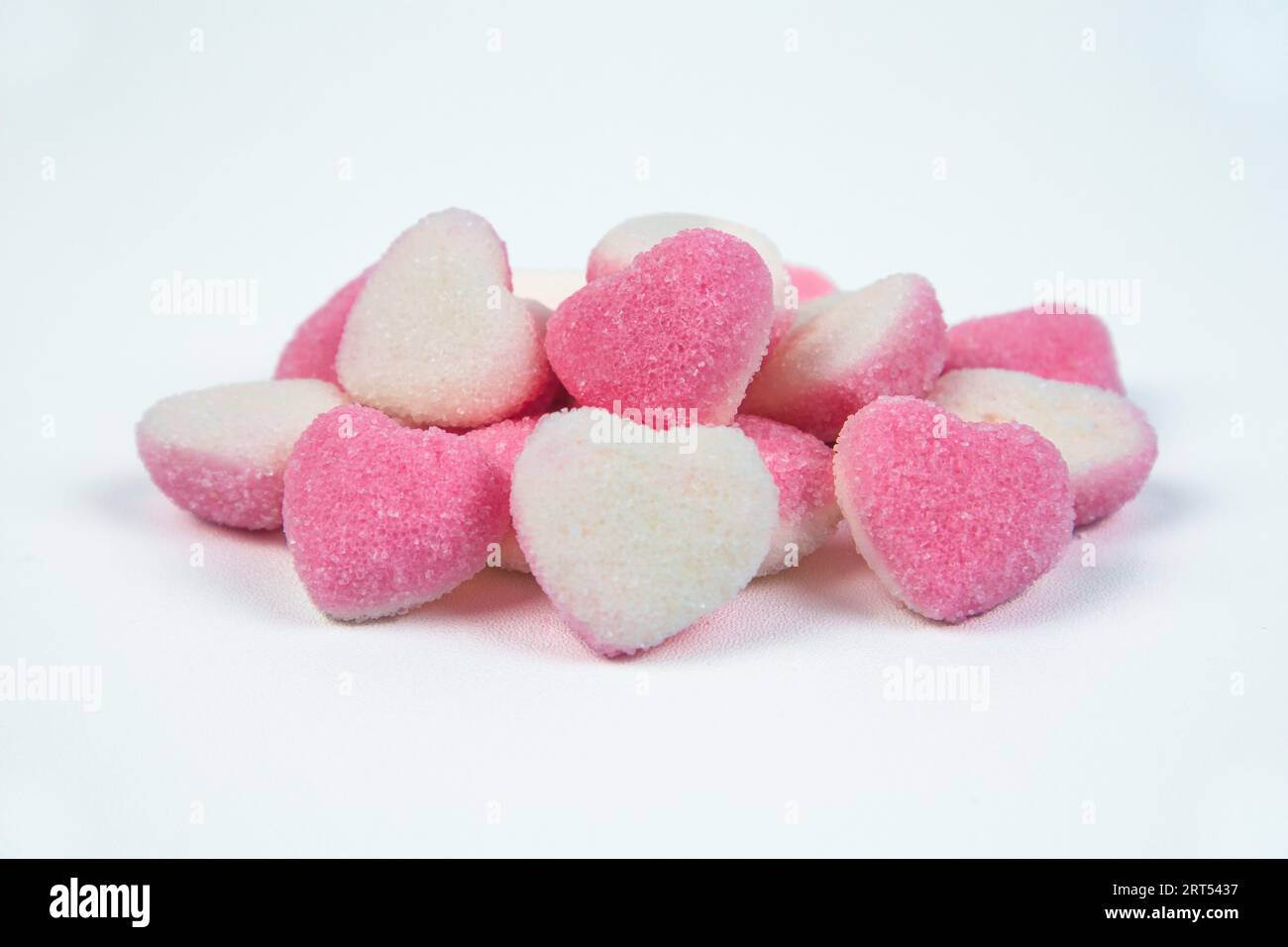 Pile de bonbons de sucre en forme de coeur sur fond blanc Banque D'Images