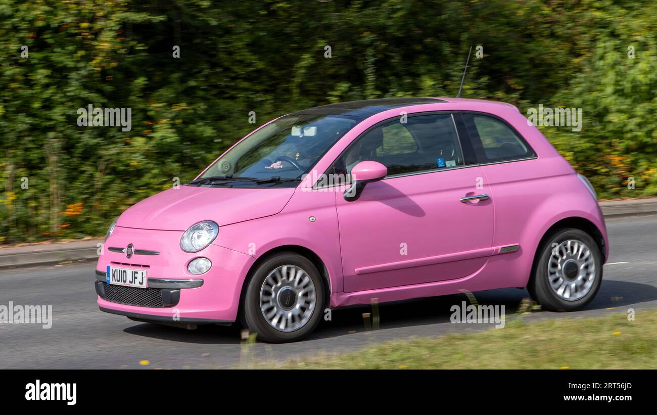 Milton Keynes,UK-10 septembre 2023 : 2010 voiture rose Fiat 500 voyageant sur une route anglaise. Banque D'Images
