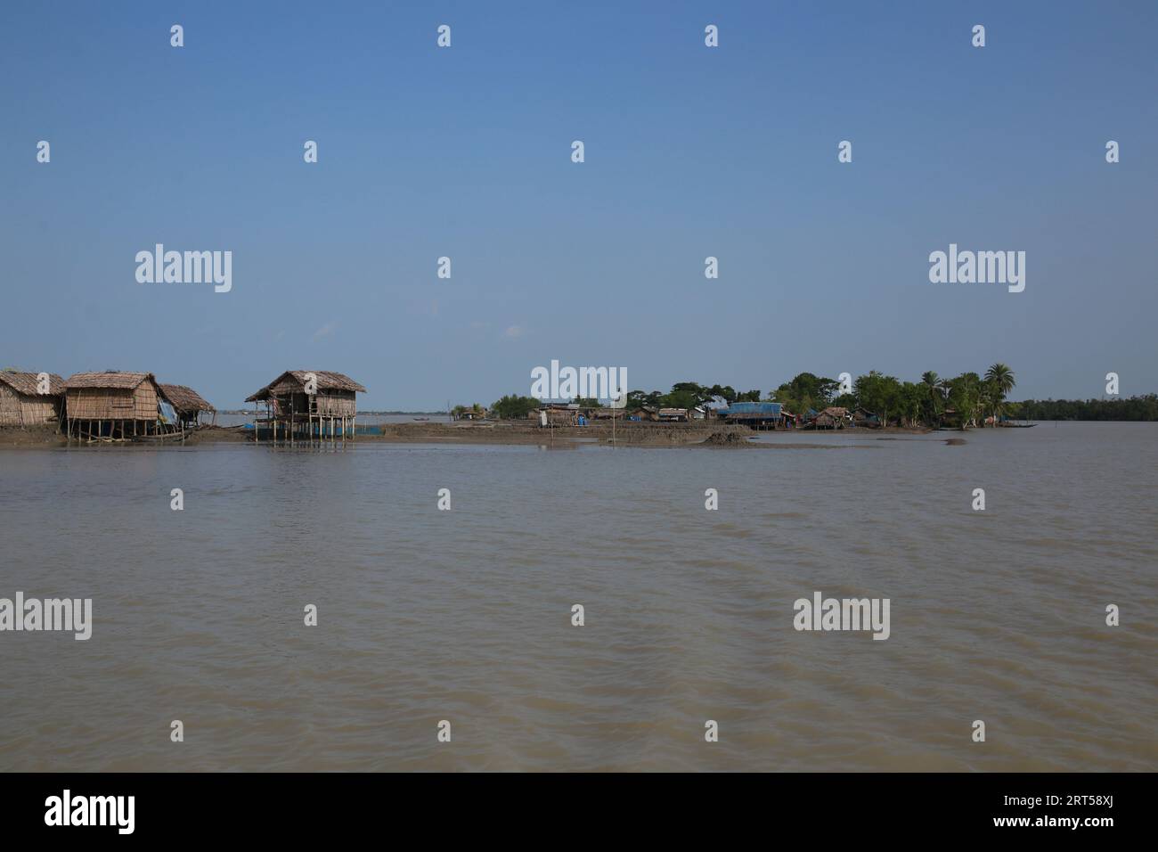 Des maisons sont vues au bord de la zone côtière des Sundarbans à Sathkhira, au Bangladesh. Des millions de personnes dans les zones côtières du Bangladesh sont menacées par le changement climatique. Banque D'Images