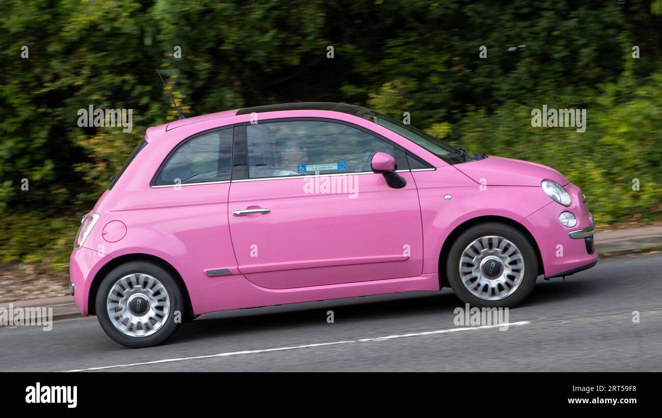 Milton Keynes,UK-10 septembre 2023 : 2010 voiture rose Fiat 500 voyageant sur une route anglaise. Banque D'Images