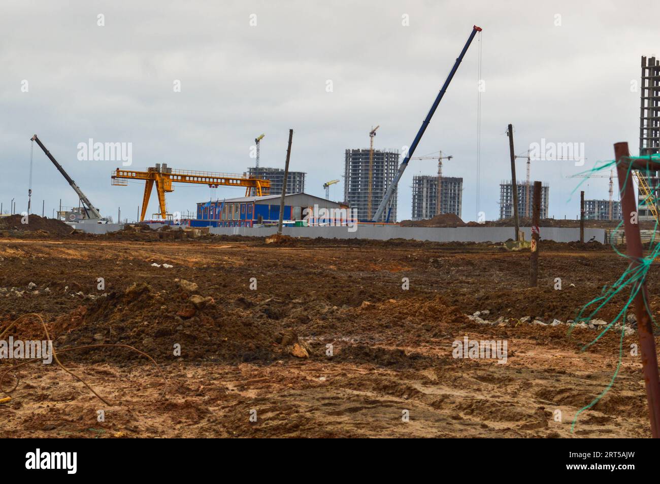 Construction d'un nouveau microdistrict avec des maisons hautes, de nouveaux bâtiments avec des infrastructures développées avec l'aide de grandes grues industrielles et profess Banque D'Images