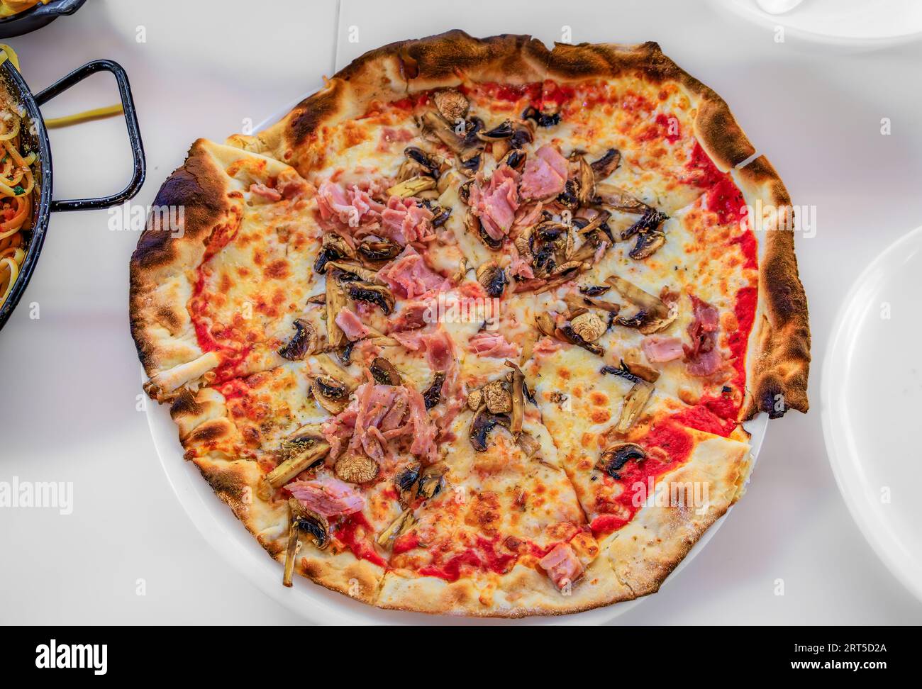 Pizza napolitaine avec sauce tomate, fromage, jambon et champignons dans un restaurant italien de la vieille ville, Vieille ville de Nice, Sud de la France Banque D'Images