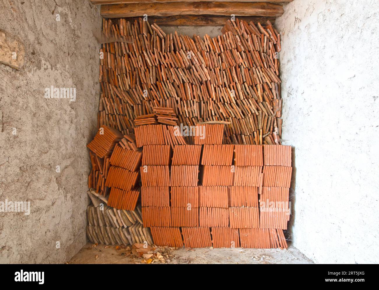 Pile de tuiles en terre cuite dans un ancien garage, France Banque D'Images